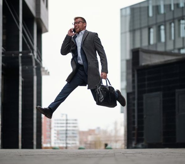 a man on a suit jumping in joy