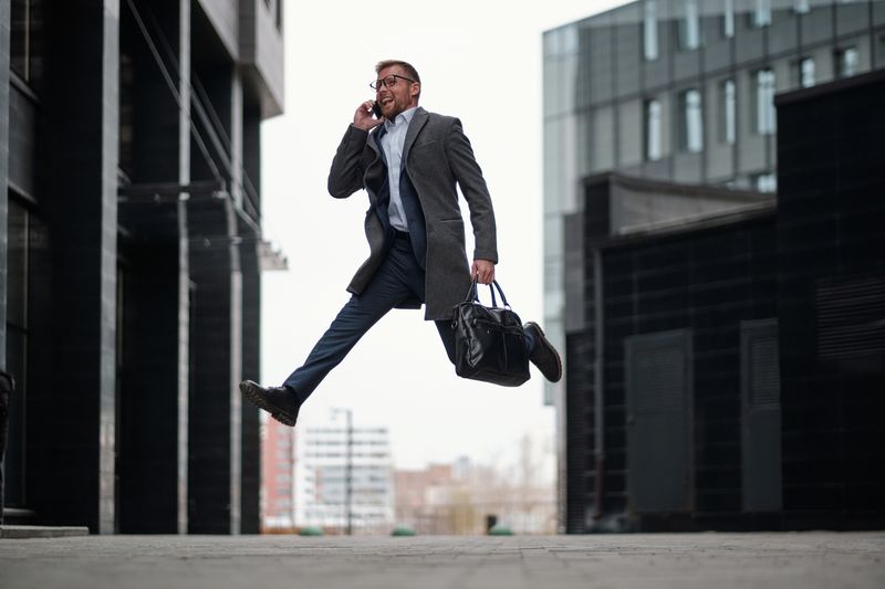 a man on a suit jumping in joy